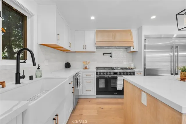 a kitchen with stainless steel appliances granite countertop a sink and a stove top oven