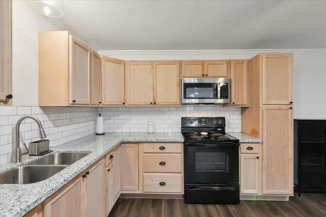 a kitchen with granite countertop a stove and a sink