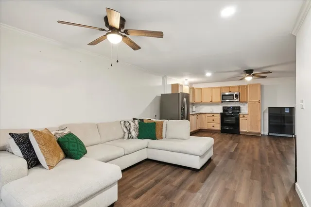 a living room with furniture kitchen view and a chandelier