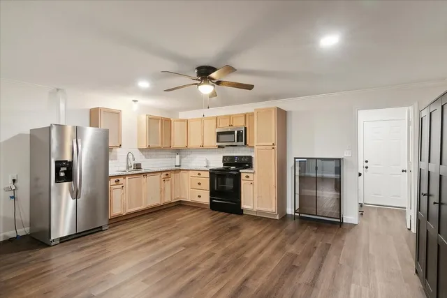 a kitchen with stainless steel appliances a refrigerator and a stove top oven