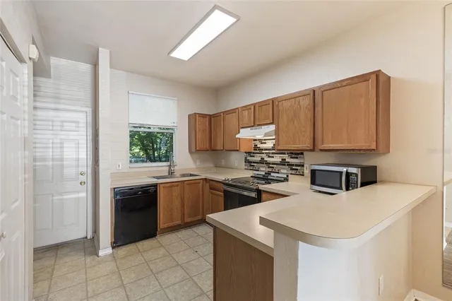 a kitchen that has a sink and a stove top oven