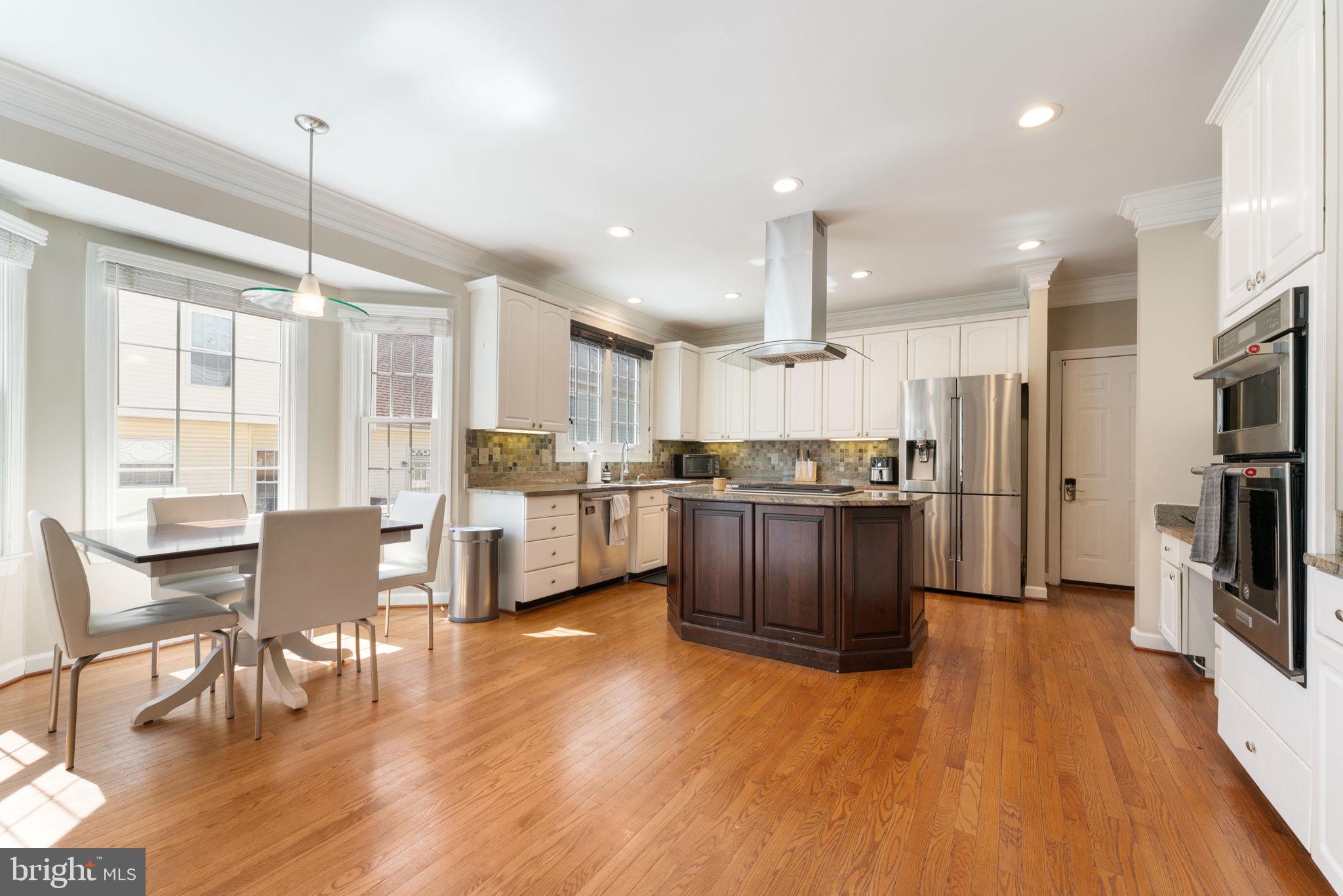 2113 Arrowleaf Drive Vienna, VA 22182 - Photo 10 of 40 a kitchen with stainless steel appliances kitchen island granite countertop wooden floors and white cabinets