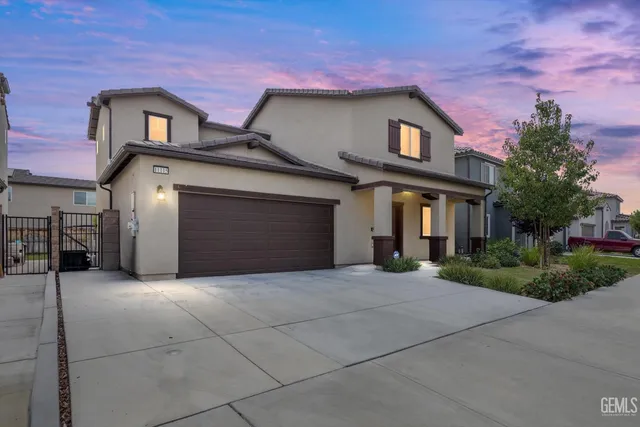 a front view of a house with yard and parking