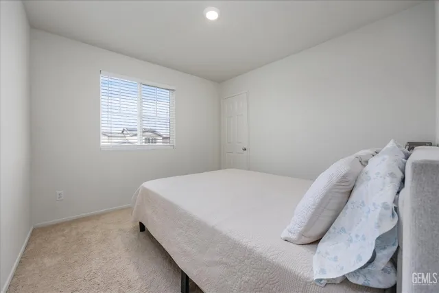 a bed sitting in a bedroom next to a window