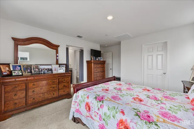 a bedroom with a bed and a dresser in it