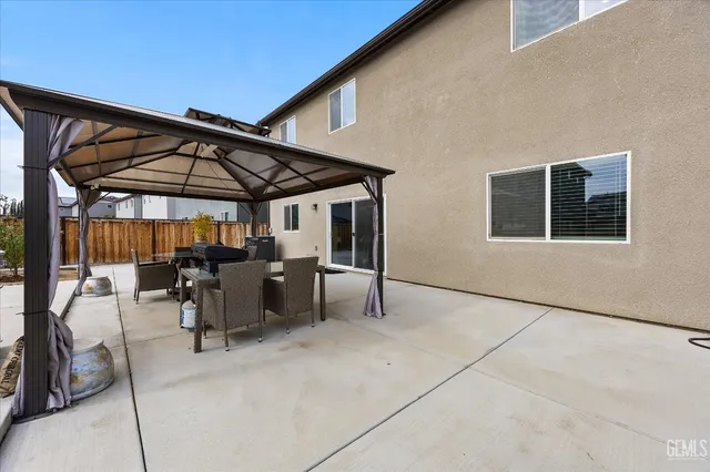 a view of a patio with a table and chairs under an umbrella