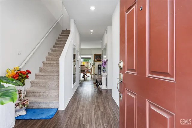 a view of a hallway with wooden floor and stairs