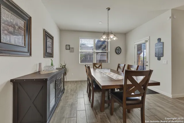 a dining room with a table chairs and kitchen view