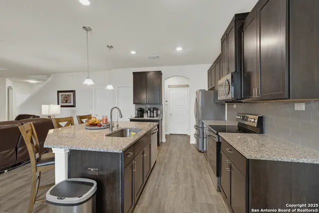 a kitchen with a stove a refrigerator and a sink