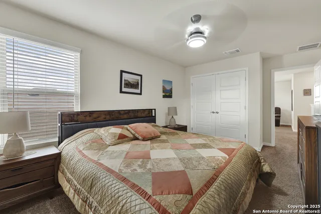 a spacious bedroom with a bed and a chandelier