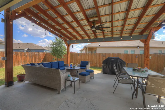a view of a patio with table and chairs potted plants with floor to ceiling window and potted plants