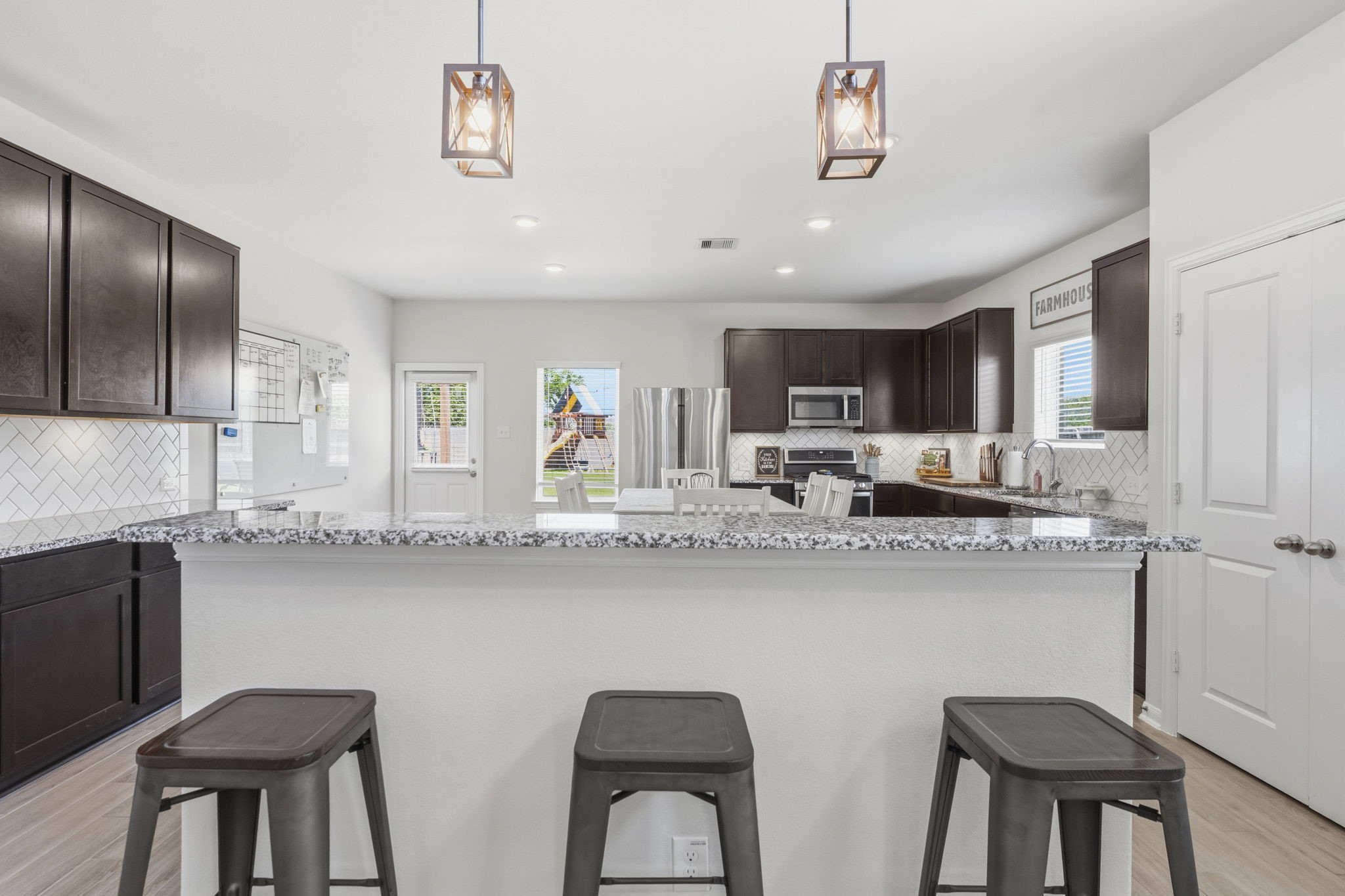 2401 Abbot Brk Drive Rosharon, TX 77583 - Photo 13 of 50 This functional kitchen island offers convenient breakfast bar seating, dramatic pendant lighting, and additional storage, making it the perfect spot for casual dining, morning coffee, or gathering with guests. Open to the family room, it enhances the home’s seamless flow and keeps everyone connected while cooking and entertaining.