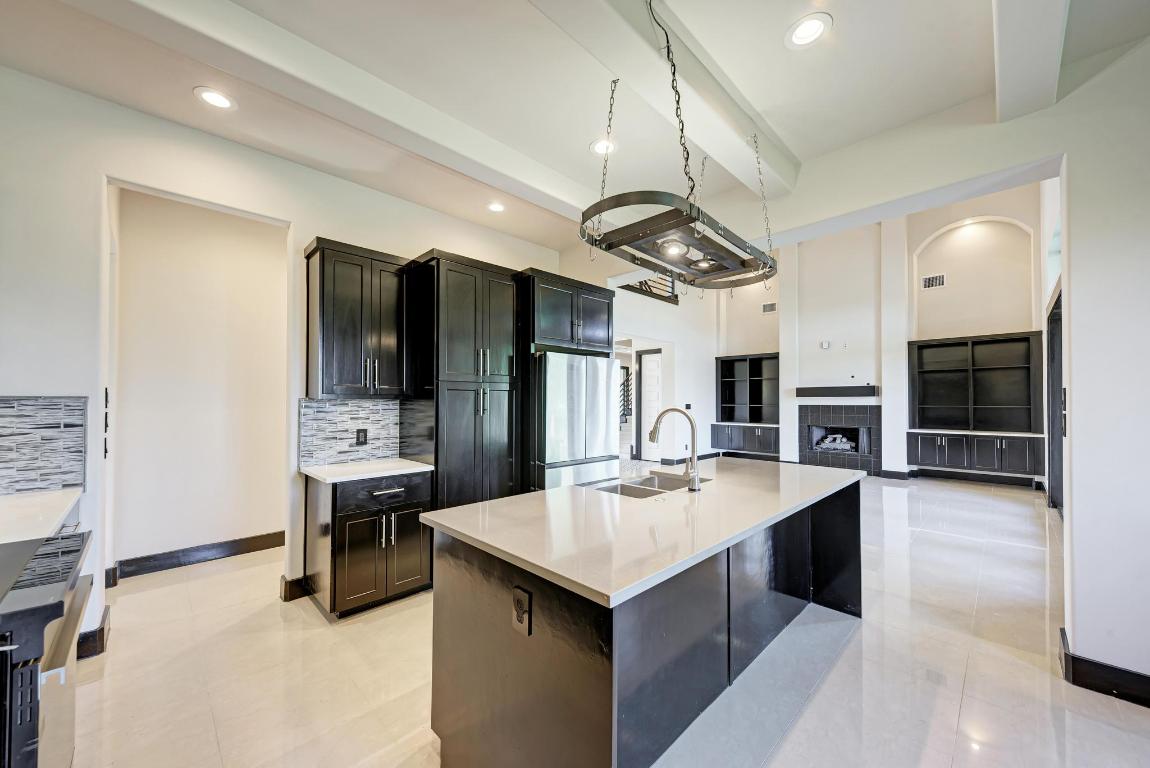 104 Spring Valley Street Hutto, TX 78634 - Photo 38 of 40 a kitchen with stainless steel appliances a sink stove and refrigerator