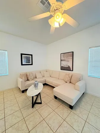 a living room with furniture and a chandelier