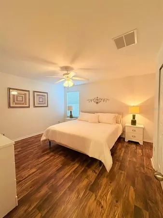 a spacious bedroom with a bed and a night stand