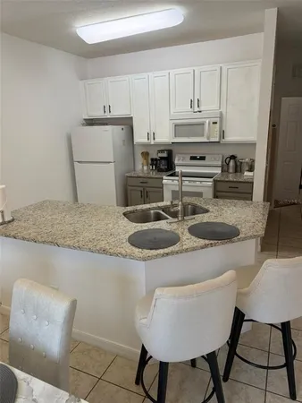 a kitchen with stainless steel appliances granite countertop a sink refrigerator and cabinets