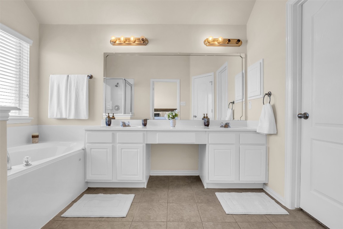 10022 Darrell Springs Lane Tomball, TX 77375 - Photo 13 of 27 a bathroom with a sink vanity tub and a mirror
