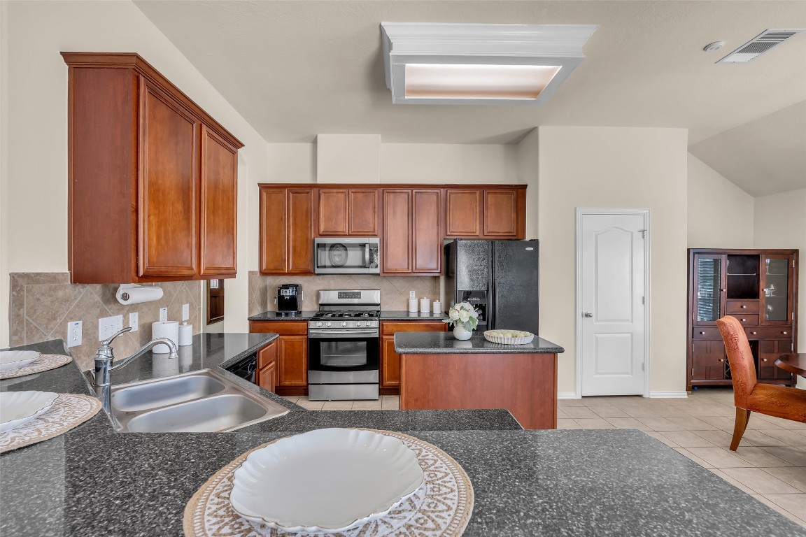 10022 Darrell Springs Lane Tomball, TX 77375 - Photo 5 of 27 a living room with stainless steel appliances furniture a rug and a view of kitchen