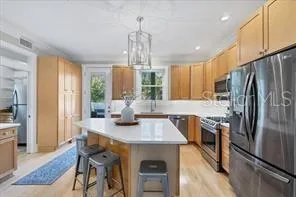 a kitchen with stainless steel appliances granite countertop a sink refrigerator and cabinets