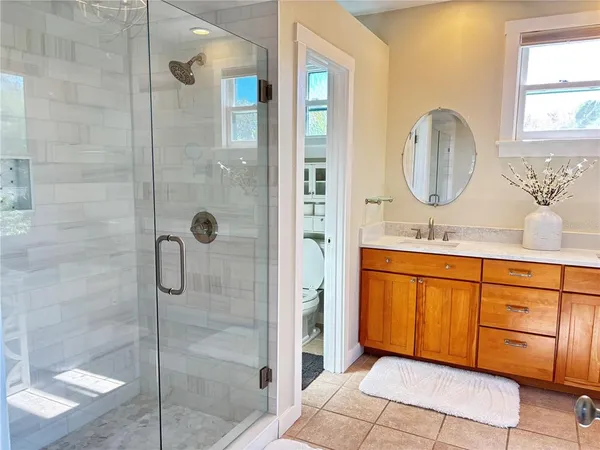 a bathroom with a double vanity sink mirror and shower