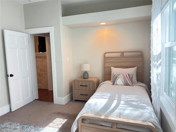 a large bed sitting in a bedroom next to a window