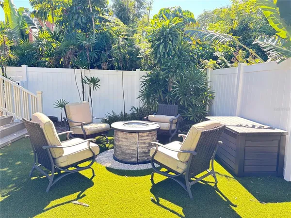 a view of a patio with table and chairs with wooden fence and plants