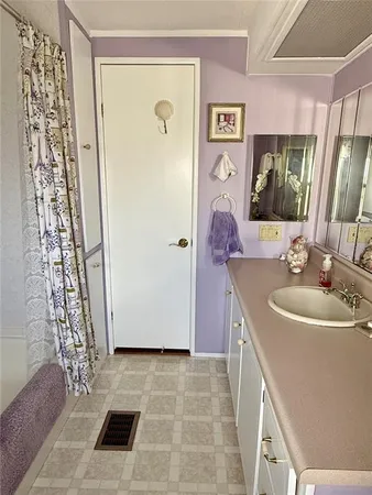 a bathroom with a sink a toilet a mirror and shower