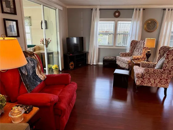a living room with furniture a flat screen tv and a large window