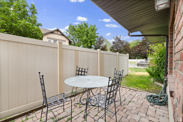 204 Lyman Lane Bountiful, UT 84010 - Photo 26 of 28 Brick patio with a privacy fence and a modest lawn area