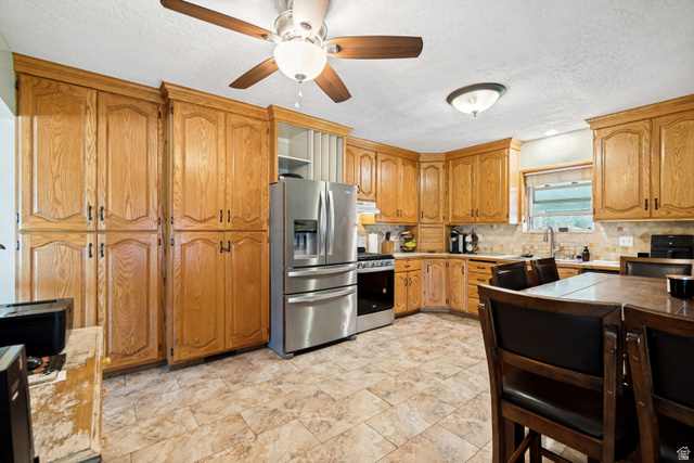 127 West 300 North Springville, UT 84663 - Photo 2 of 24 Kitchen featuring extensive wood-finish cabinetry, stainless steel appliances, tile flooring, and a ceiling fan