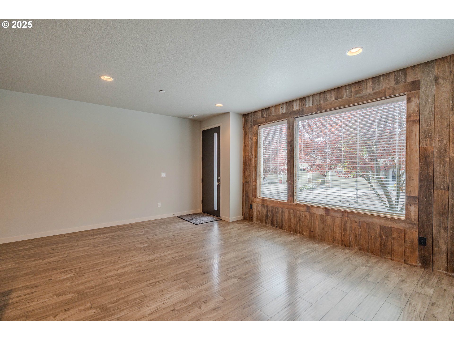 122 North 43rd Place Ridgefield, WA 98642 - Photo 5 of 41 an empty room with wooden floor and windows