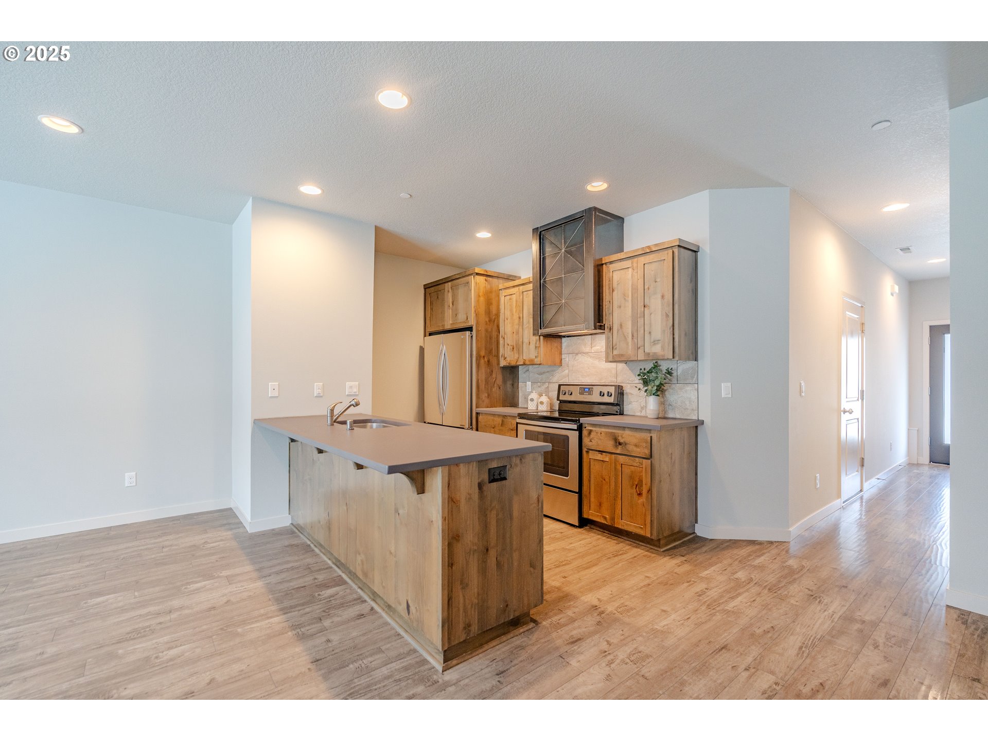 122 North 43rd Place Ridgefield, WA 98642 - Photo 8 of 41 a kitchen with stainless steel appliances a sink a stove a refrigerator cabinets and living room view