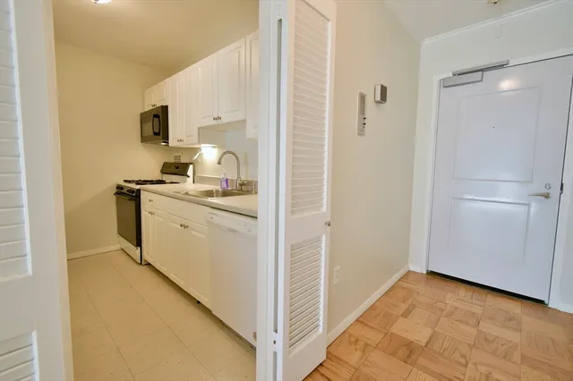 a view of a kitchen with white cabinets