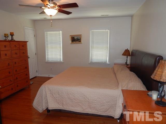 1505 Park Ridge Way Raleigh, NC 27614 - Photo 14 of 25 a bed sitting in a bedroom next to a window with a chandelier
