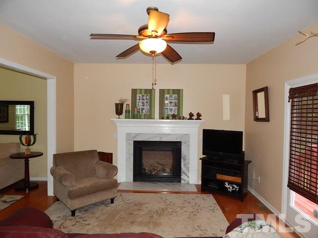 1505 Park Ridge Way Raleigh, NC 27614 - Photo 3 of 25 a living room with furniture a fireplace and a flat screen tv