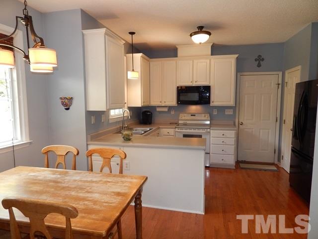 1505 Park Ridge Way Raleigh, NC 27614 - Photo 8 of 25 a kitchen with stainless steel appliances granite countertop a stove a refrigerator a oven a sink with a dining table and chairs