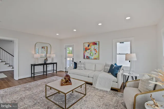 a view of a livingroom with furniture hardwood floor and a large window