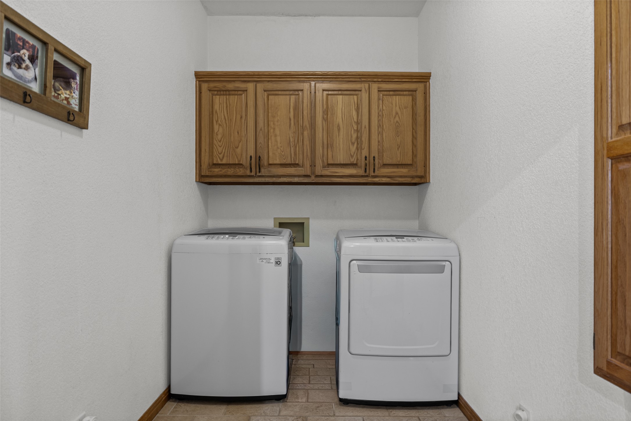 2000 Spinel Road Pflugerville, TX 78660 - Photo 10 of 31 Functional laundry space featuring convenient washer and dryer units with overhead storage cabinetry.
