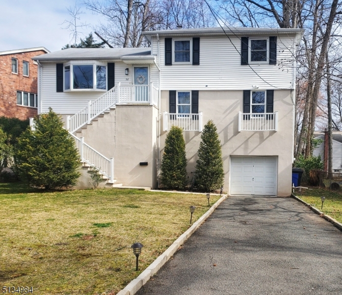 512 Riverside Drive Cranford, NJ 07016 - Photo 3 of 22 a front view of a house with a yard and garage