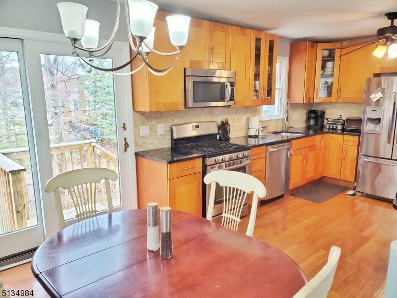 512 Riverside Drive Cranford, NJ 07016 - Photo 10 of 22 a kitchen with stainless steel appliances granite countertop a stove a sink a microwave and dining table