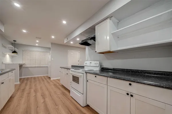 a kitchen with granite countertop a sink stainless steel appliances and cabinets