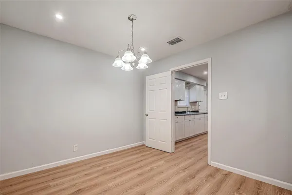 a view of a kitchen with wooden floor and a chandelier