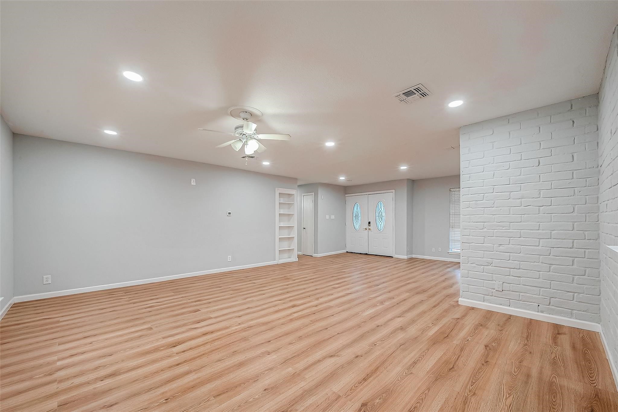 23131 Earlmist Drive Spring, TX 77373 - Photo 9 of 34 a view of an empty room with wooden floor and a ceiling fan