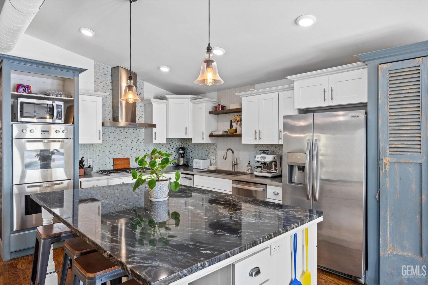 Undisclosed Address Bakersfield, CA 93306 - Photo 17 of 39 a kitchen with a refrigerator a sink and a center island