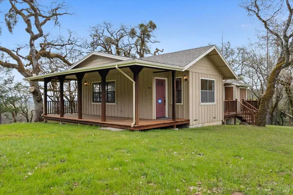 a view of a house with yard and sitting area