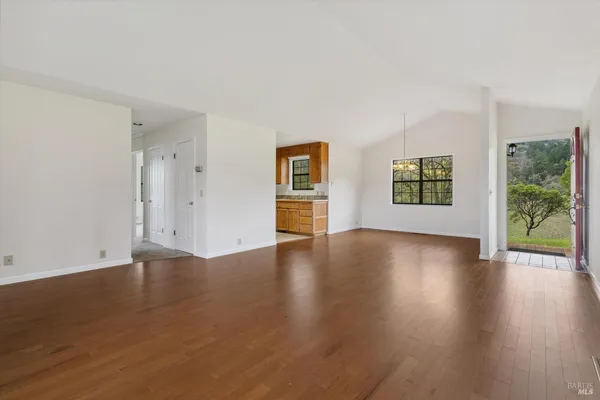 a kitchen with granite countertop a sink cabinets stainless steel appliances and a window