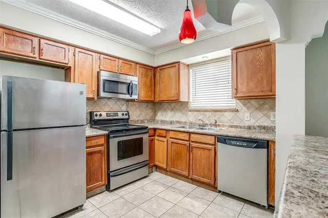 a kitchen with granite countertop a sink stainless steel appliances and cabinets