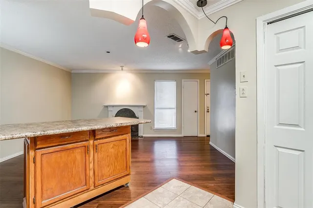 a kitchen with granite countertop a stove and a wooden floor