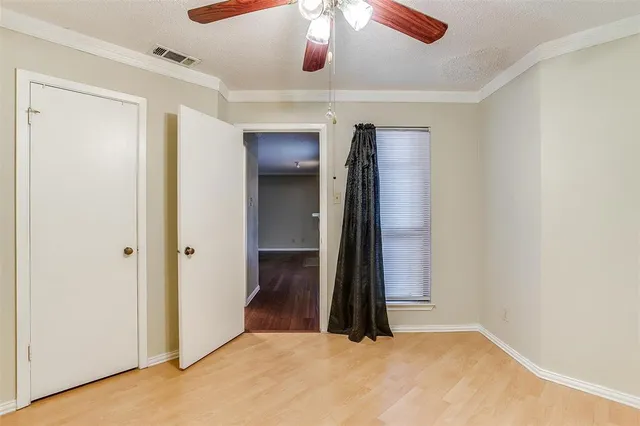 an empty room with closet and a ceiling fan