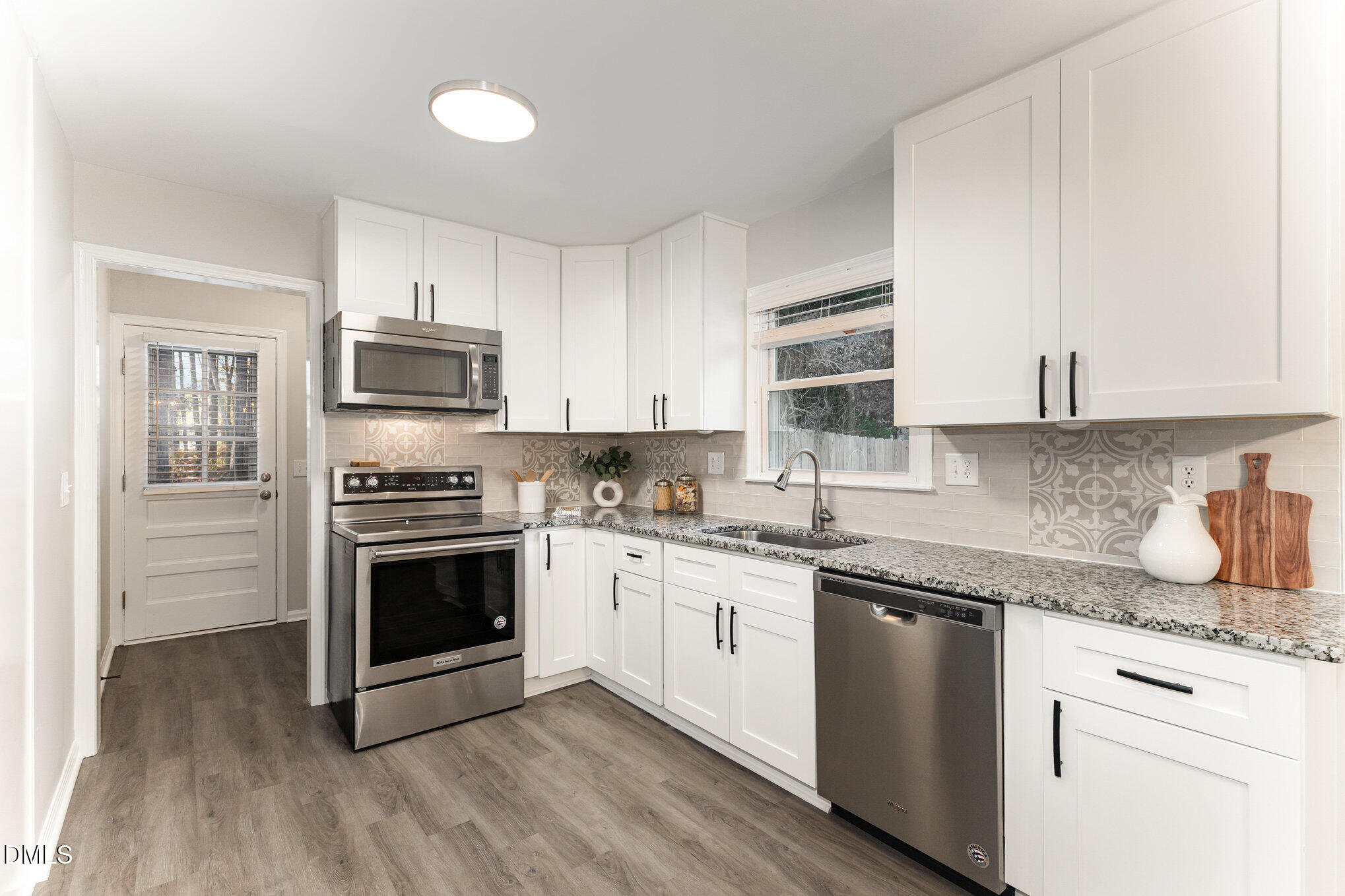 7717 Cart Track Trail Raleigh, NC 27615 - Photo 11 of 18 a kitchen with cabinets stainless steel appliances a sink and wooden floor